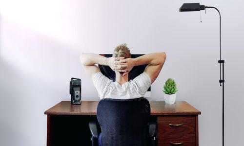 A man is resting at his desk