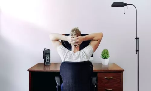 A man is resting at his desk
