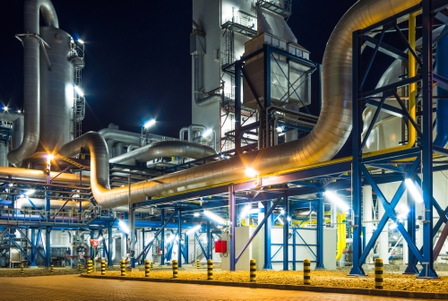 Pumps and piping system in industrial plant at night