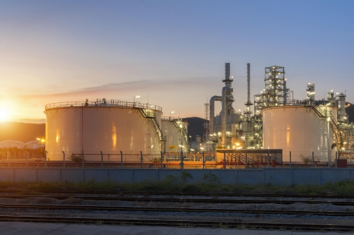 Gas storage tank and columns at LNG plant during sunset